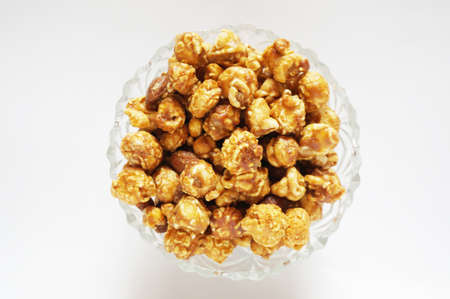 Caramel popcorn on glass bowl isolated on white backgroundの写真素材