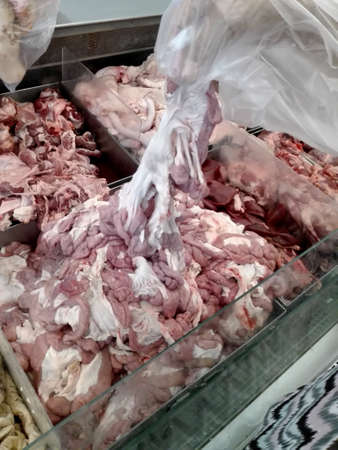 Fresh raw entrails or pork organs for sale in a market with hand pick up chitterlingsの写真素材
