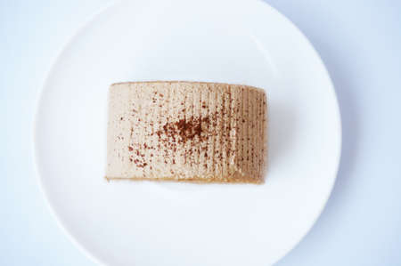 Colorful cream coffee cake roll on white plate isolated on white backgroundの写真素材