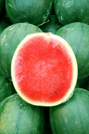 Closeup of flesh watermelon cut in half with watermelon backgroundの写真素材