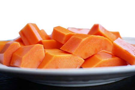 Slices of ripe sweet papaya on white plate isolated on white backgroundの写真素材