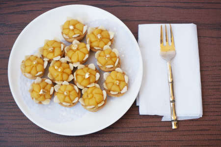 Asia - Asian eating food, Thai dessert, Ja Mongkut is the name of Egg Yolk Dumpling in Wheat Flour. Made from wheat flour, egg, sugar, coconut milk surrounded with watermelon seed and look like a crown, on wooden backgroundの写真素材