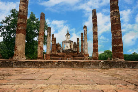 A photo of ruin of Buddha and stone pillar under the blue sky, is a World Heritage at Sukhothai Historical Park, Sukhothai, Thailand (Thai alphabet in the picture means "Don't climb".)の写真素材