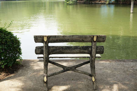 A wood bench of relaxing corner next to a pond in the parkの写真素材
