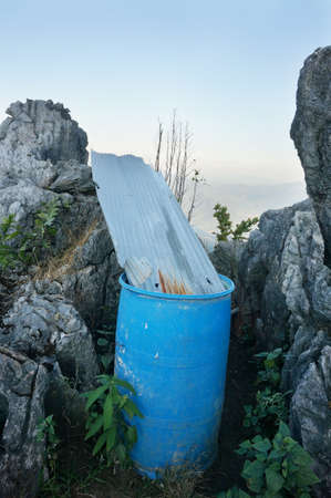 A photo of plastic container and galvanized wave steel between the rock on the mountain at Mount Pha Tang, northern of thailandの写真素材
