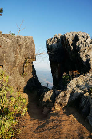 A photo of cliff between two rocky hill with trees growing on rock, landscape at Mount Pha Tang, northern of thailandの写真素材