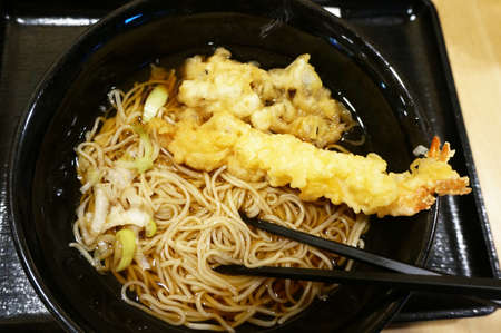Asia - Asian eating food, Japanese food, Soba noodle in ramen soup with shrimp Tempura and Oyster mushroom Tempura, close upの写真素材