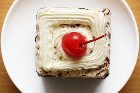 Colorful chocolate black forest cake decorated with cherry on wooden background, close upの写真素材