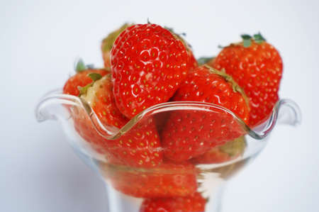 Close up of photo of very fresh harvested strawberries on ice-cream glass isolated on white backgroundの写真素材