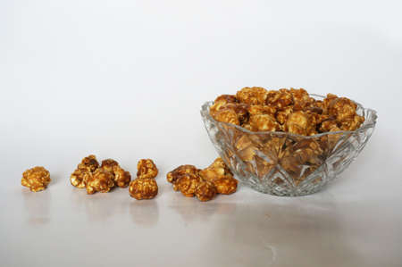 A photo of caramel popcorn on glass blow isolated on white background, close upの写真素材