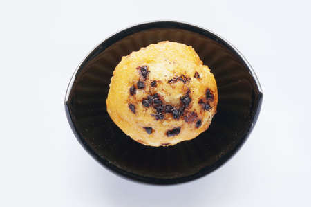 A photo of colorful butter muffin decorated with chocolate topping on black bowl isolated on white background, close upの写真素材