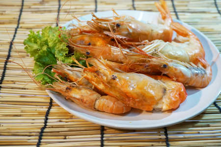 Steamed giant river prawns on rattan curtain backgroundの写真素材