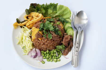 Asia - Asian eating food, Thai food, Fried rice mixed with shrimp paste served with sweet pork, Thai omelet and vegetables isolated on white background, close upの写真素材