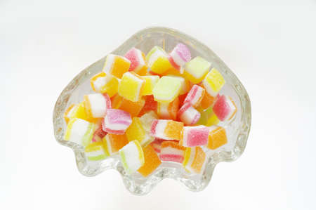 Photo of various color of fruity gummy jelly candies in glass bowl isolated on white backgroundの写真素材