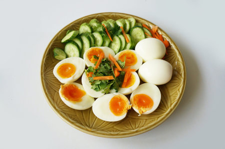 A photo of Hard - boiled eggs with cucumber, carrot and coriander on plate isolated on white background, close upの写真素材