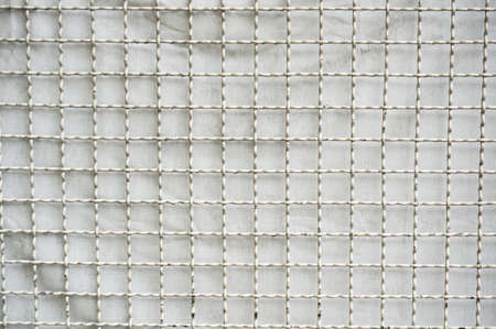 A photo of background of wire mesh fence pattern texture, close upの写真素材