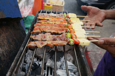 A photo of grilled chicken and pork barcebue on a stove, close upの写真素材
