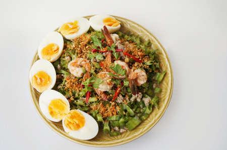Asia-Asian eating food, Thai foof, Yum Tua Poo: Spicy Shrimp and betel nuts salad or Winged bean salsa, with boil eggs isolated on white background, close upの写真素材