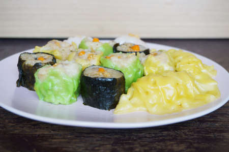 Asia - Asian eating food, Chinese food, Dim Sum: Chinese Steamed Dumpling and Shumai on plate on wooden background, close upの写真素材
