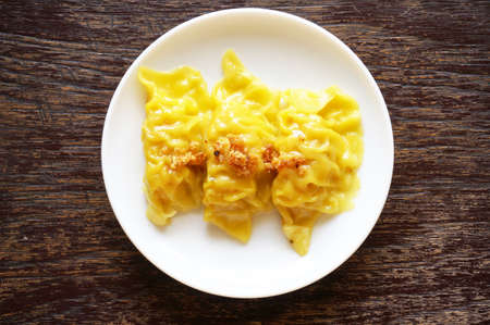 Asia - Asian eating food, Chinese food, Wonton Dim Sum: Chinese Steamed Dumpling, a steamed Wonton on white plate on wooden background, close upの写真素材