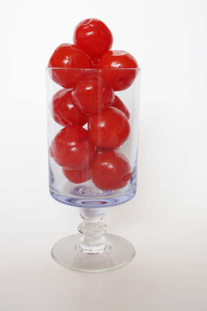 A photo of maraschino cherries in champagne glass isolated on white backgroundの写真素材