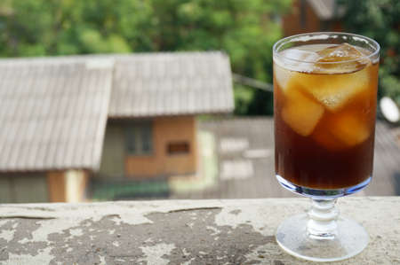 Cola, black coffee, on champagne glass on balcony of an old buildingの写真素材