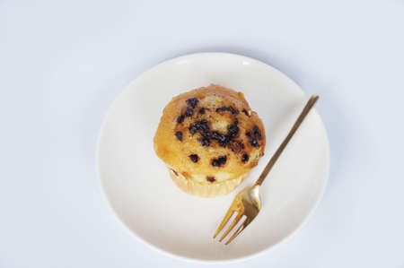 A photo of colorful butter muffin decorated with chocolate topping on white plate isolated on white backgroundの写真素材