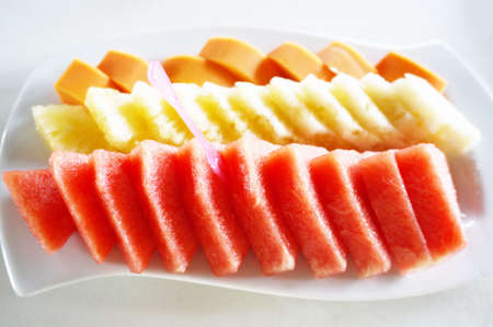 Fresh mixed fruits for eat, sliced of papaya, pineapple, watermelon on white plate isolated on white background, close upの写真素材