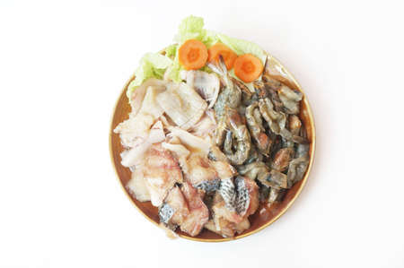 Raw foods: Fresh squid, white leg shrimp or pacific white shrimp (Litopenaeus vannamei, formerly Penaeus vannamei) and fish with chinese cabbage on plate isolated on white background, close upの写真素材