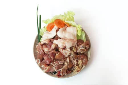 Row food: fresh pork cut meat and lard with vegetables- spring onion, chinese cabbage, carrot on plate isolated on white background, close upの写真素材