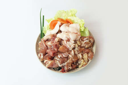 Row food: fresh pork cut meat and lard with vegetables- spring onion, chinese cabbage, carrot on plate isolated on white background, close upの写真素材
