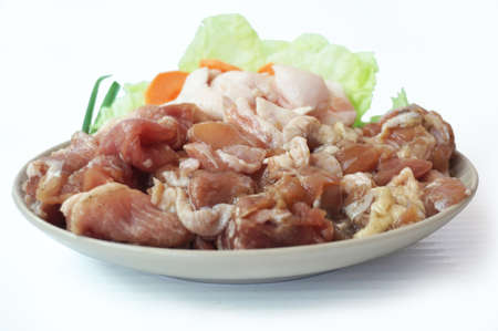 Row food: fresh pork cut meat and lard with vegetables- spring onion, chinese cabbage, carrot on plate isolated on white background, close upの写真素材