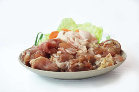 Row food: fresh pork cut meat and lard with vegetables- spring onion, chinese cabbage, carrot on plate isolated on white background, close upの写真素材