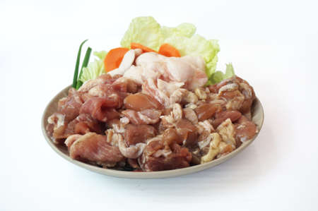 Row food: fresh pork cut meat and lard with vegetables- spring onion, chinese cabbage, carrot on plate isolated on white background, close upの写真素材