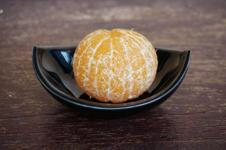 Close up of photo of very fresh orange on black blow on wooden backgroundの写真素材