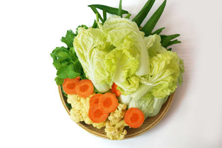 Vegatables set - diet food for health: green sweet basil (Thai basil), Celery (Smallage), morning glory, cauliflower, Chinese cabbages and orange carrots on plate isolated on white backgroundの写真素材