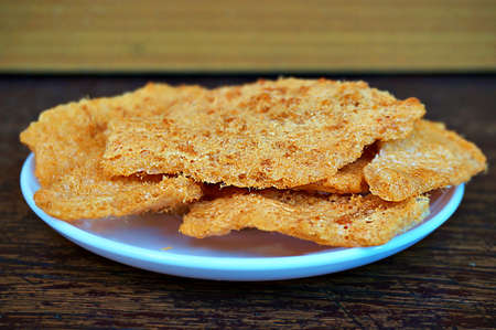Asia-Asian, Thai food: a photo of Dried shredded flossy pork Rice cracker on white plate on wooden background, close upの写真素材