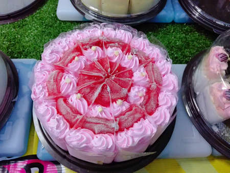 A photo of colorful cream strawberry cake decorated with  topping on sale at streed food market of thailand, close upの写真素材