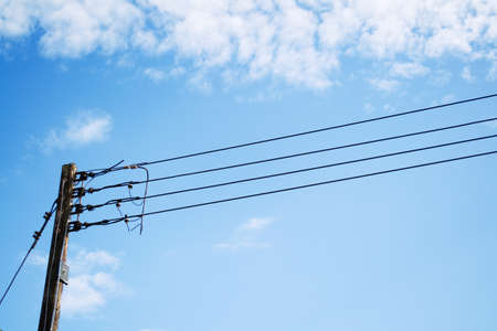 Electricity poles and wires with blue sky.の写真素材