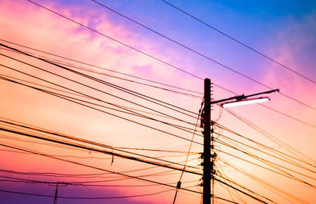 electricity poles at sunset with colorful cloudの写真素材