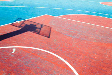 Concrete basketball court is empty in outdoor basketball field with shadow hoopの写真素材