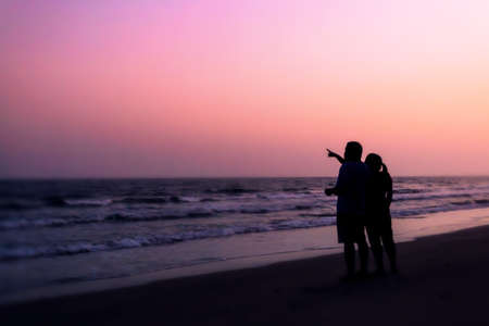 silhouette of couples hugging on the beach on the beach with sunrise in the sea for valentine's dayの写真素材