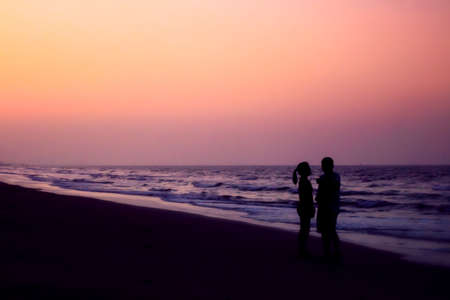 silhouette of couples hugging on the beach on the beach with sunrise in the sea for valentine's dayの写真素材