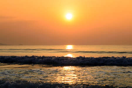 Sunset on the beach with wave of seaの写真素材