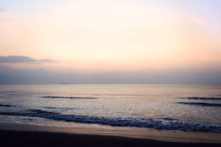 Sunrise on the beach with wave of seaの写真素材