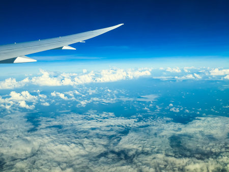 window view in airplane above the blue sky with cloud