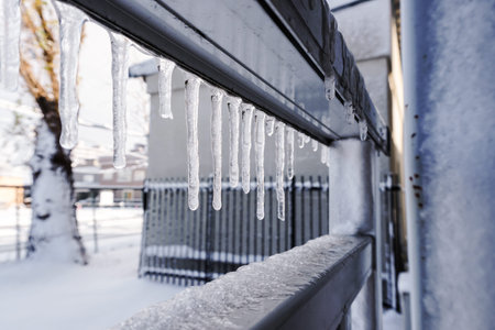 Icicle melt is hanging from a roofの写真素材