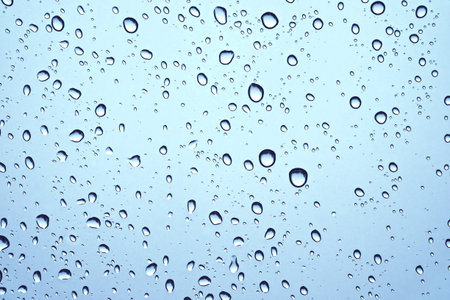 CLOSE UP IMAGE OF RAIN DROPS ON GLASS WINDOW