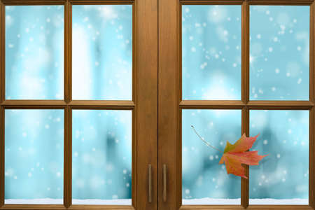 Wooden window frame with outside view of snow and nice freezing blue tone bokeh in background.の写真素材