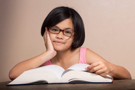 Girl wearing glasses reading at home